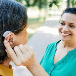 Woman with hearing aid talking to her friend.