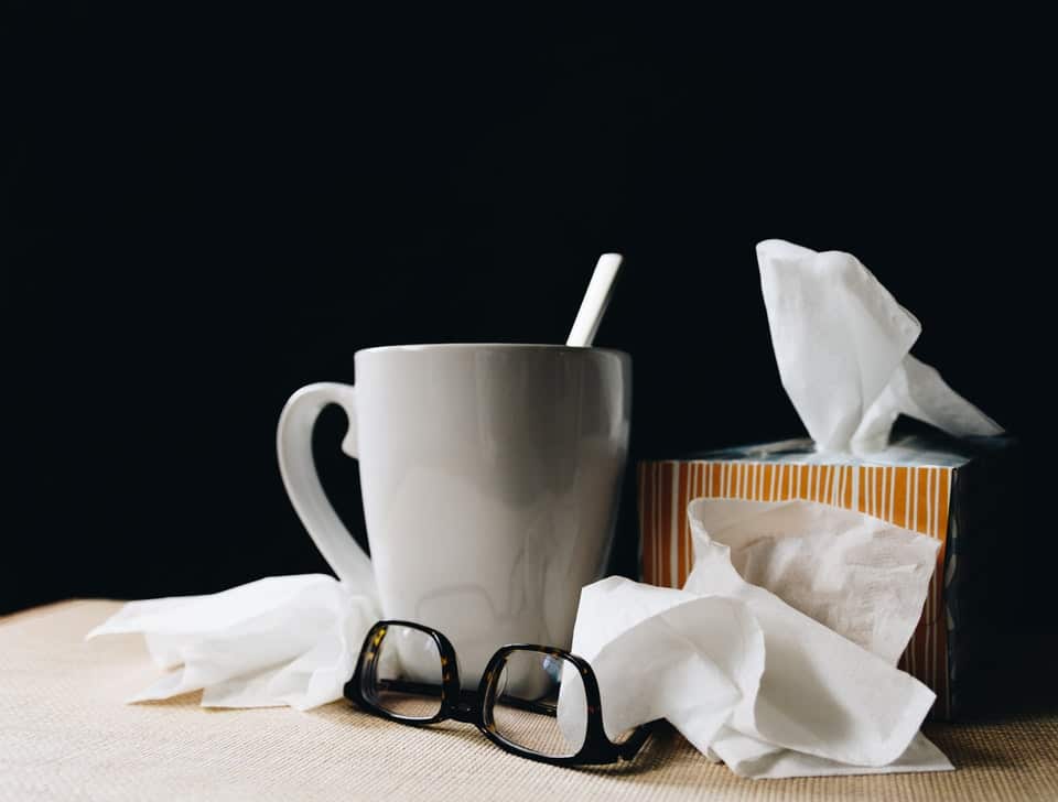 A box of tissues next to a mug and some glasses.