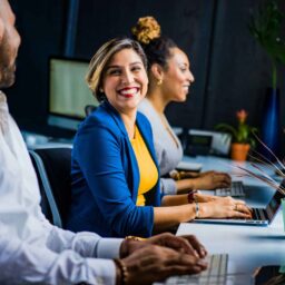 A woman smiling at her coworkers in the office.