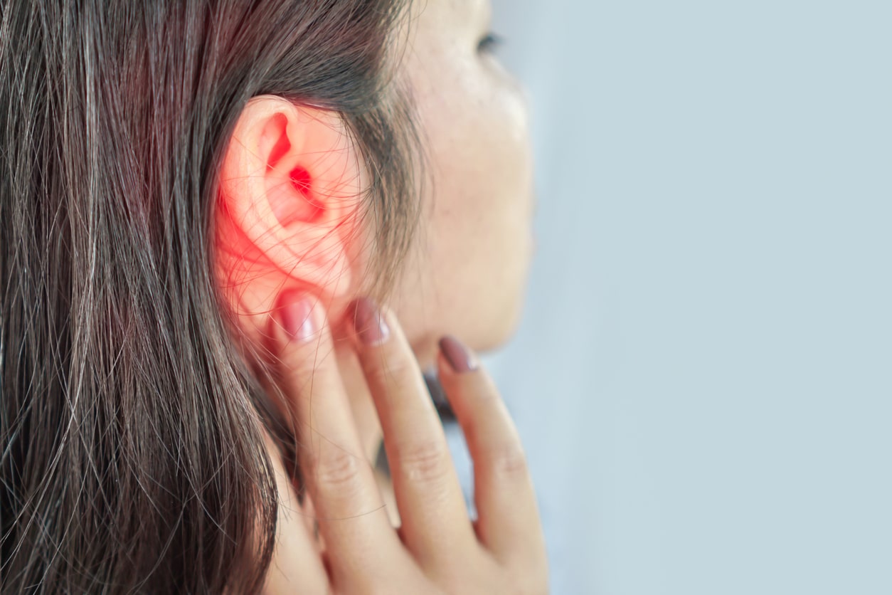 Woman touching ear suffering from ear pain.