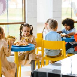 Group of young schoolchildren eating lunch.