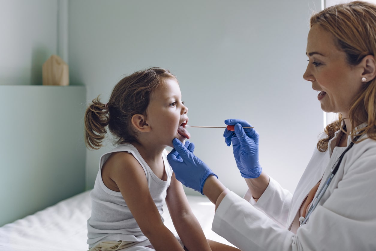 Young girl having her tonsils checked.