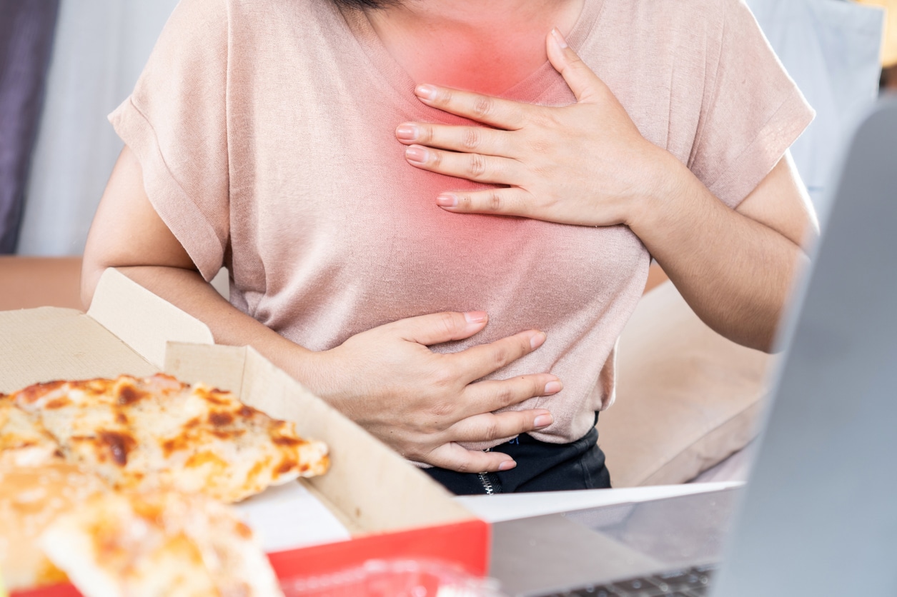 Woman with heartburn holding her chest.