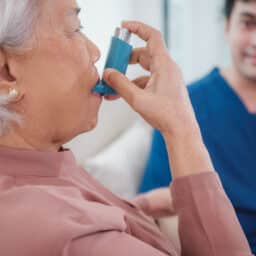 Senior woman using her inhalers a the doctor's office